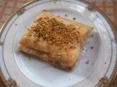 Mutabbak (Buttery Phyllo dessert with melted cheese, pistachios, and sweet lemon syrup)