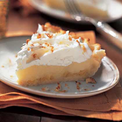 A slice of coconut cream pie with whipped cream topping