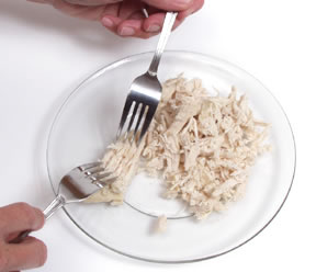 Take two forks with their backs facing each other and shred the chicken 