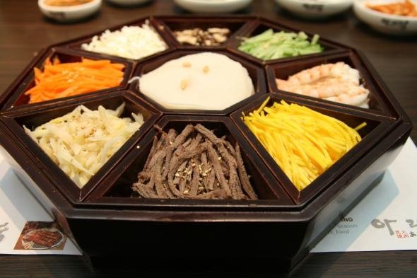 A tray full of garnishments are served along with Janchi Guksu, the diners can build their own soup using these ingredients